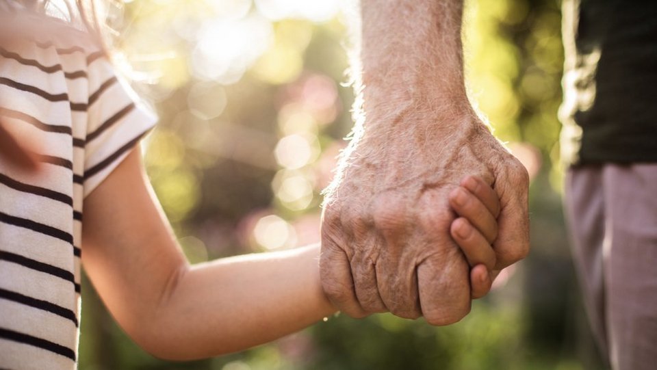 Kind an der Hand eines Erwachsenen